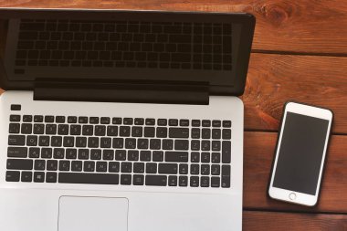 Dizüstü bilgisayar ve telefon ahşap arka plan üzerinde