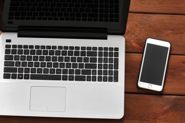 Dizüstü bilgisayar ve telefon ahşap arka plan üzerinde