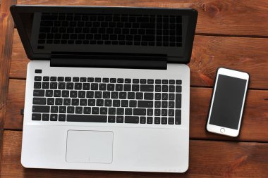 Dizüstü bilgisayar ve telefon ahşap arka plan üzerinde