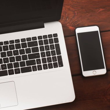 Dizüstü bilgisayar ve telefon ahşap arka plan üzerinde