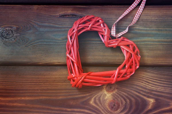 Wicker hjärta på en trä bakgrund. Kärlek — Stockfoto