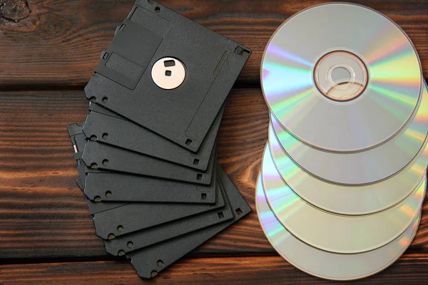 Floppy disks and disks on wooden background