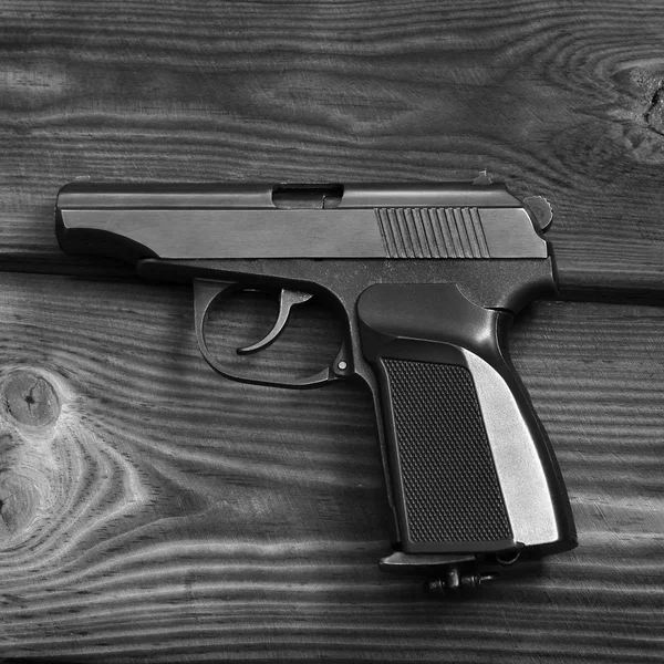 Arma. Pistola en el fondo de madera — Foto de Stock