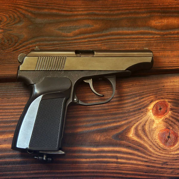 Pistola sullo sfondo di legno. Arma — Foto Stock