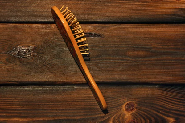 Кисть для волос на деревянном фоне — стоковое фото