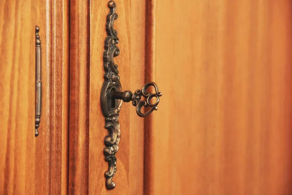 Una vieja llave antigua en la cerradura. Muebles de madera — Foto de Stock