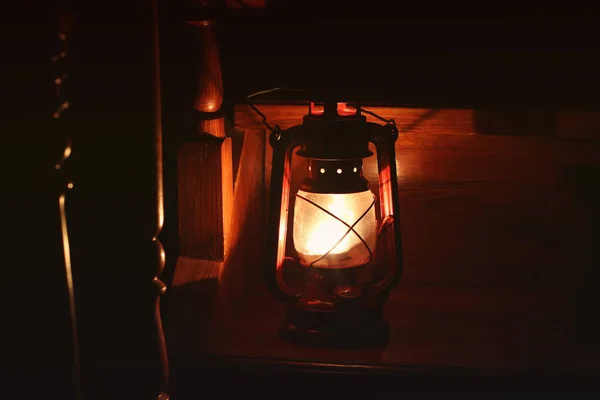 Kerosene lamp in the dark. The lamp on the wooden stairs