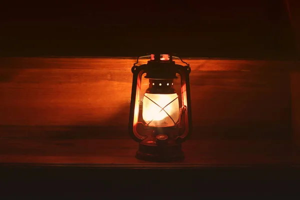 Kerosene lamp in the dark. Light on wooden background — Stock Photo, Image