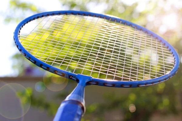 Badminton racket close-up tegen een achtergrond van bomen — Stockfoto