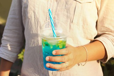 Bir kızın elinde kokteyl. Elinde sulu içki