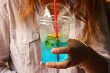 Bir kızın elinde kokteyl. Elinde sulu içki