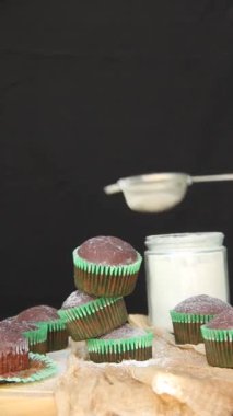 Adam pudra şekerli çörekler serper.