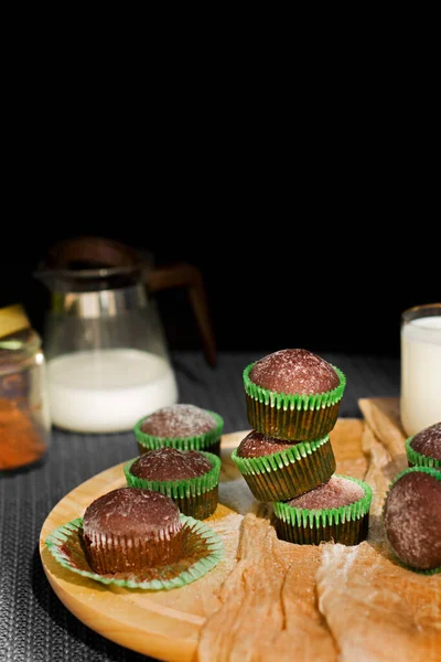 暗い背景にチョコレートマフィン 粉砂糖マフィン 牛乳とカップケーキ ベーカリー製品 — ストック写真