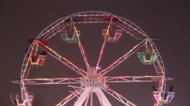 Işıklı dönme dolap. Atlıkarınca yaklaşıyor. Noel ışıkları. Geceleyin çekimler