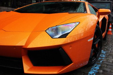 Turuncu bir arabanın parçası. Yağmur damlalarında araba