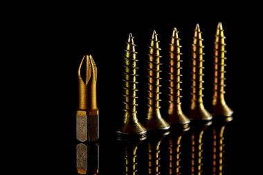 Ufak tefek tornavida vidaları karanlık bir arka plan üzerinde yer alır. Yakın çekim shot. Arka plan olarak kullanılabilir