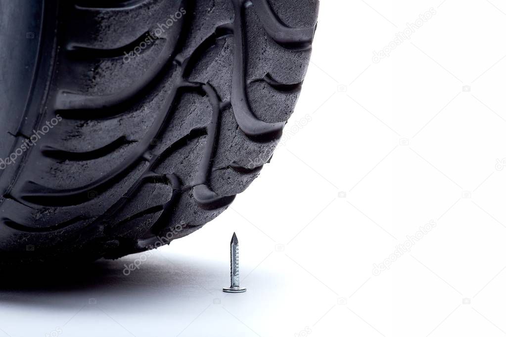 The moment of puncture of destruction of a wheel at a meeting with a nail on a white background