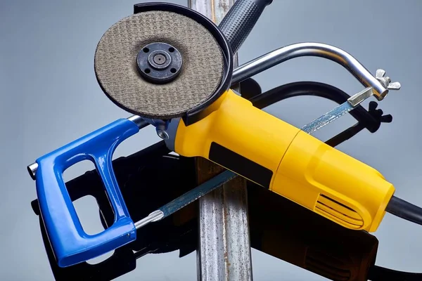 Ecke elektrische Schleifmaschine mit Stein für Metall und Säge auf Metall liegen auf dunklem Hintergrund Nahaufnahme — Stockfoto