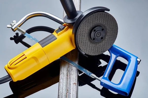 Ecke elektrische Schleifmaschine mit Stein für Metall und Säge auf Metall liegen auf dunklem Hintergrund Nahaufnahme — Stockfoto