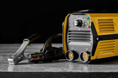 Çevirici kaynak makinesi. Ahşap bir masaüstünde metal kaynaklama ekipmanı.