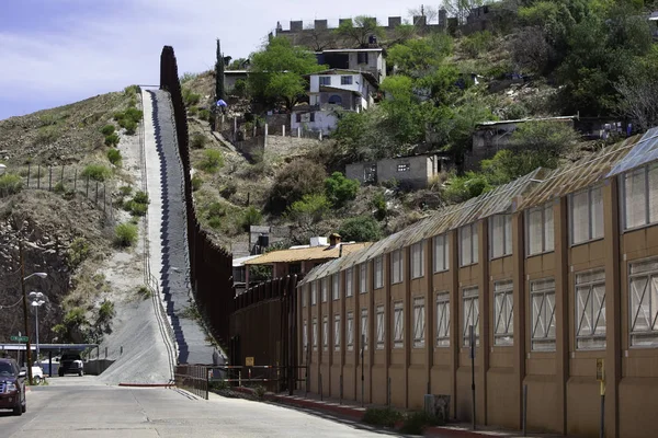United States border wall with Nogales Mexico neighborhood on the right