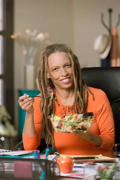 Vrouw met Drealocks Eet een gezonde lunch aan haar bureau — Stockfoto
