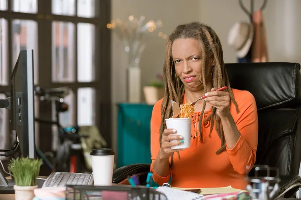 Mujer infeliz con su almuerzo de fideos en el trabajo — Foto de Stock