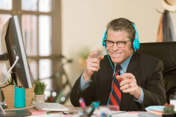 Knappe creatieve zaken man die naar een koptelefoon luistert en — Stockfoto