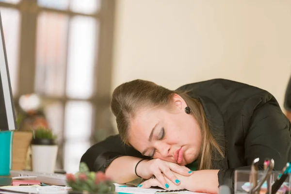 Mujer cansada durmiendo en su escritorio —  Fotos de Stock