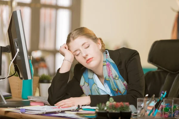 Mujer agotada durmiendo en su escritorio —  Fotos de Stock