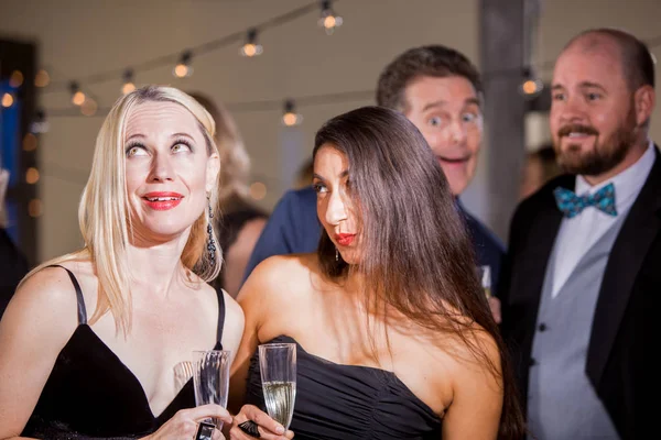 Due donne osservate dagli uomini alla festa — Foto Stock