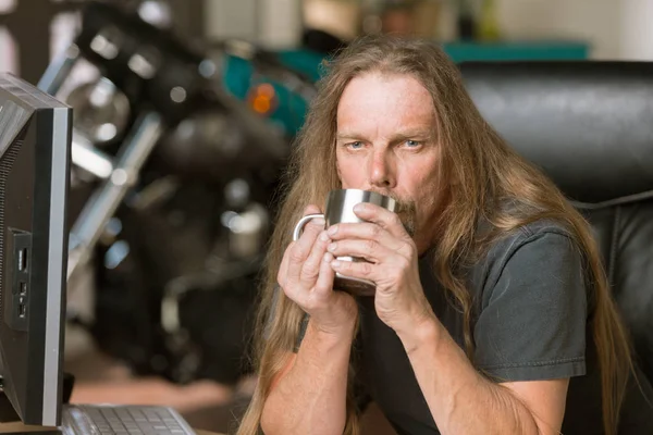 Sleepy Man at his Desk with Coffee and Motorcycle in the Backgro — Stock Photo, Image