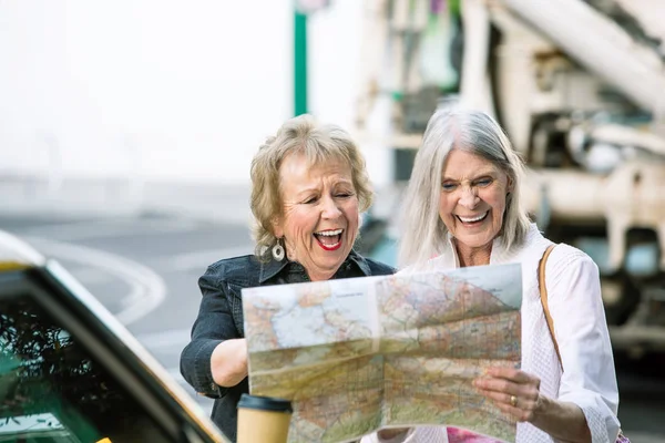 Zwei Frauen prüfen eine Landkarte und lachen — Stockfoto