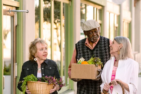 Lächelnde Senioren kehren mit Lebensmitteln vom Bauernmarkt zurück — Stockfoto