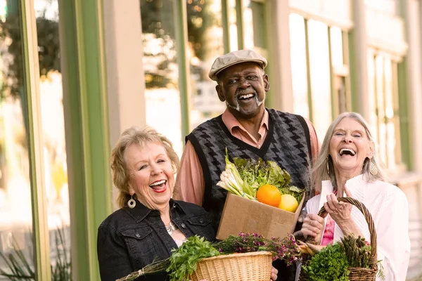 Rire des aînés revenant du marché agricole avec des produits alimentaires — Photo