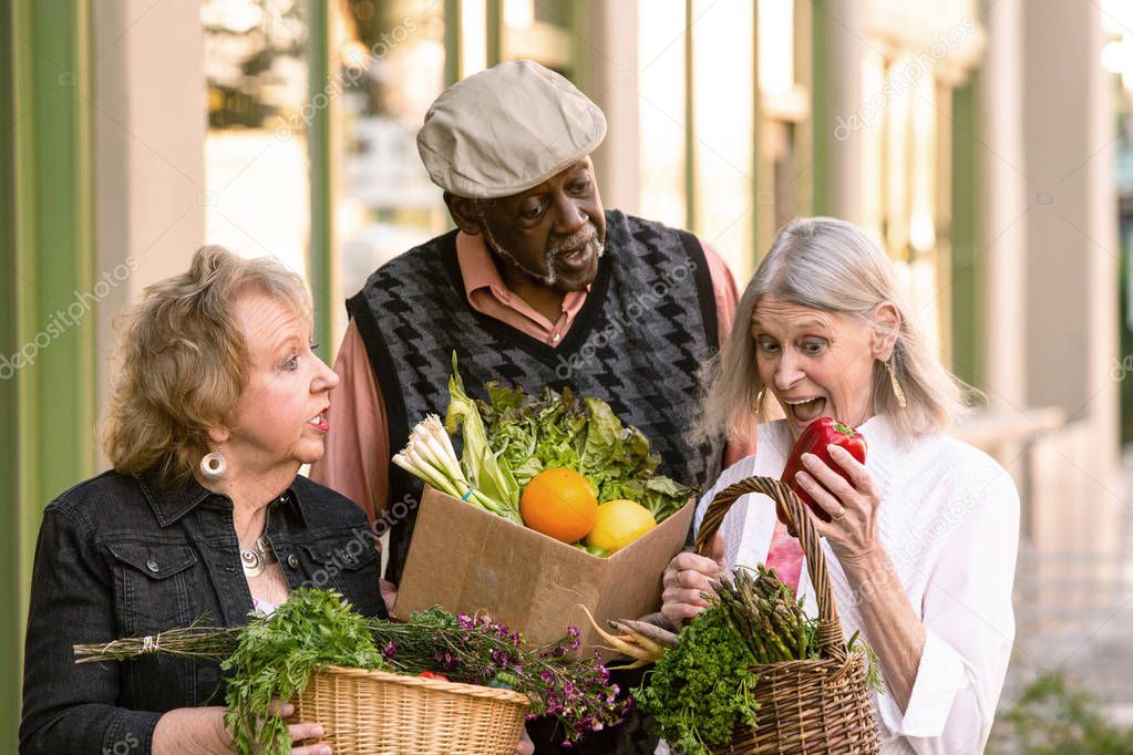 Three Seniors Comparing Purchases from Farmers Market 