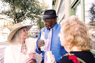 Üç son sınıf öğrencisi ellerinde burritolarla