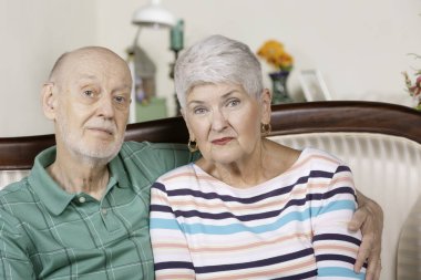 Evdeki yaşlı adam ve kadın endişeli ya da üzgün.