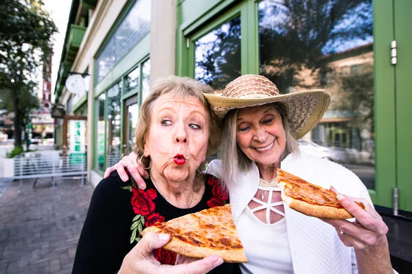 ストリートフードピザを食べる二人の面白い先輩女性 — ストック写真