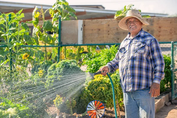 Imagem Horizontal Sorrir Homem Hispânico Regando Jardim Comunitário — Fotografia de Stock