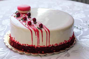 Kırmızı meyveler ve macaron tarafından dekore edilmiş lezzetli beyaz ev yapımı kek. Modern fotoğraf.