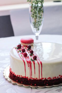 Kırmızı meyveler ve macaron tarafından dekore edilmiş lezzetli beyaz ev yapımı kek. Modern fotoğraf.