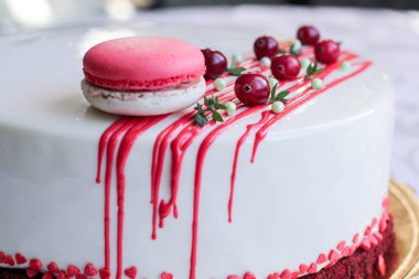 Kırmızı meyveler ve macaron tarafından dekore edilmiş lezzetli beyaz ev yapımı kek. Modern fotoğraf.