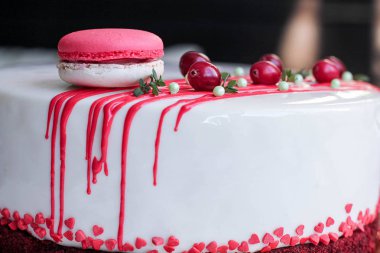Kırmızı meyveler ve macaron tarafından dekore edilmiş lezzetli beyaz ev yapımı kek. Modern fotoğraf.