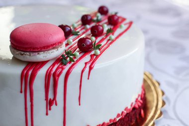Kırmızı meyveler ve macaron tarafından dekore edilmiş lezzetli beyaz ev yapımı kek. Modern fotoğraf.
