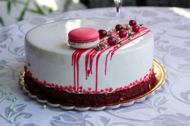 Kırmızı meyveler ve macaron tarafından dekore edilmiş lezzetli beyaz ev yapımı kek. Modern fotoğraf.