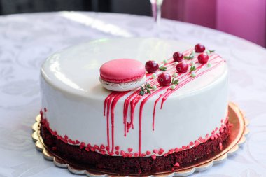 Kırmızı meyveler ve macaron tarafından dekore edilmiş lezzetli beyaz ev yapımı kek. Modern fotoğraf.