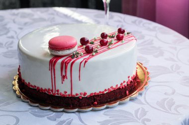 Kırmızı meyveler ve macaron tarafından dekore edilmiş lezzetli beyaz ev yapımı kek. Modern fotoğraf.