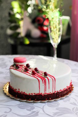 Kırmızı meyveler ve macaron tarafından dekore edilmiş lezzetli beyaz ev yapımı kek. Modern fotoğraf.