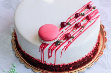 Kırmızı meyveler ve macaron tarafından dekore edilmiş lezzetli beyaz ev yapımı kek. Modern fotoğraf.